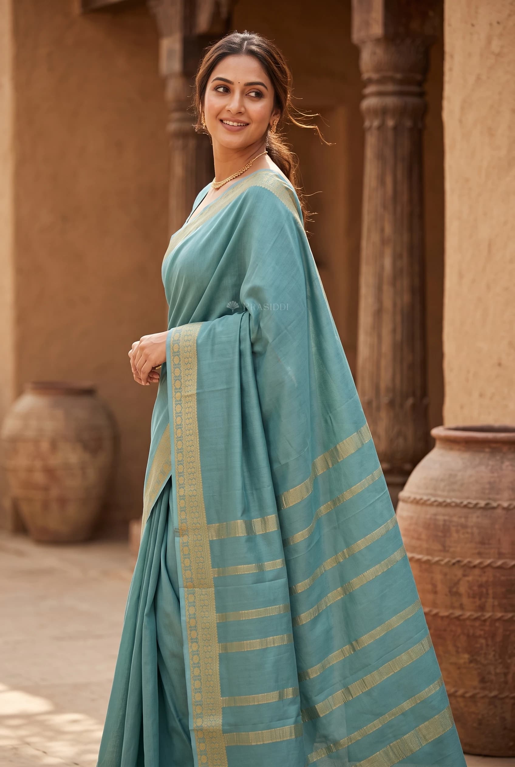 Teal Blue Mysore Silk Saree with a Classical Border and Sparse Woven Design. – Model Displaying Full Saree